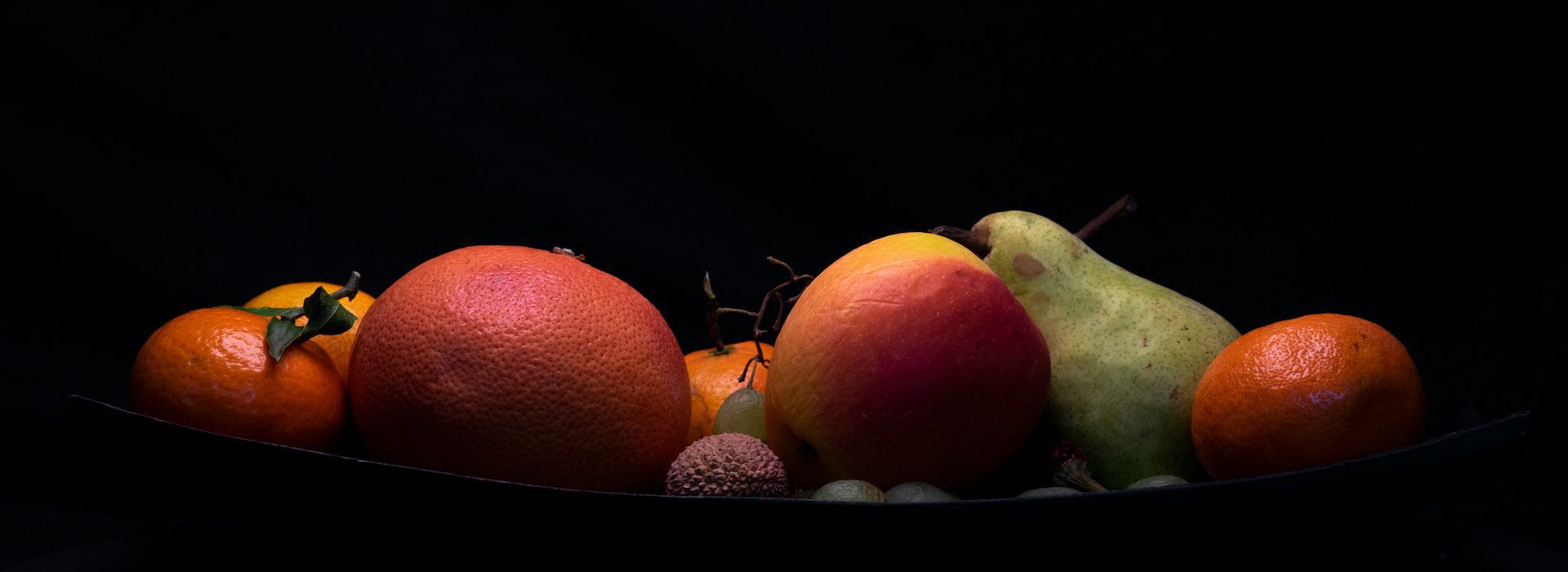 Früchte in einer Schale im dunklen Raum